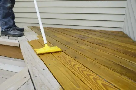 person staining deck