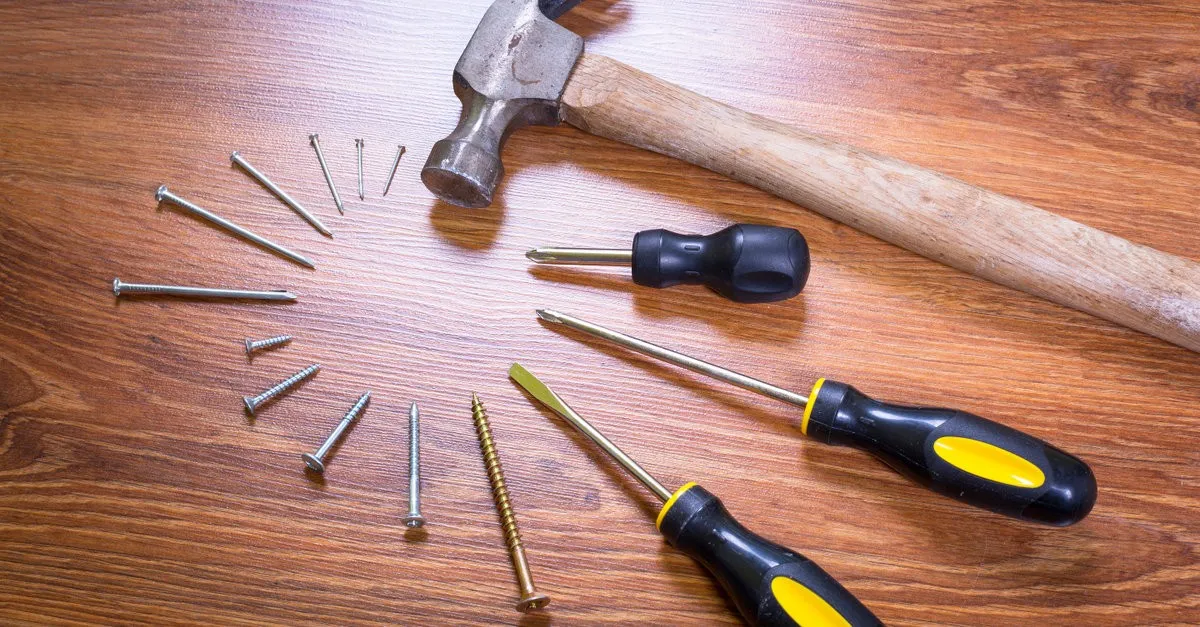 Various tools, nails, and screws used by handyman to perform fence repair in Boulder, CO
