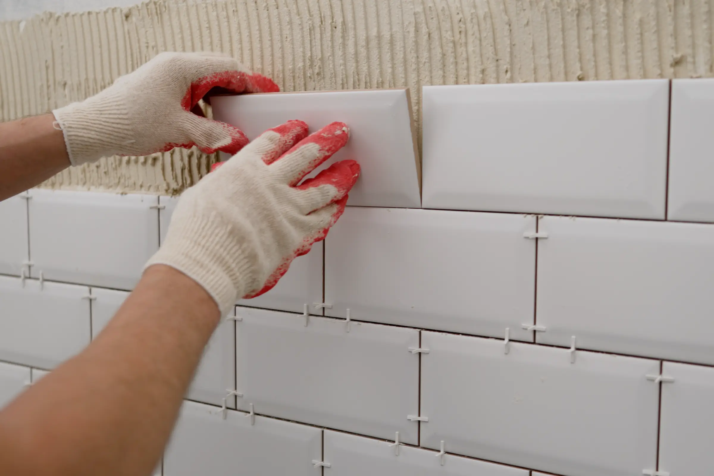 A person performs grout repair in their bathroom.