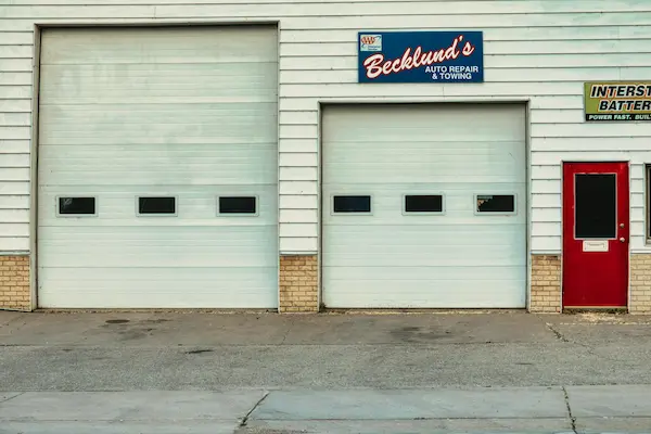 Brick commercial building with white garage doors.