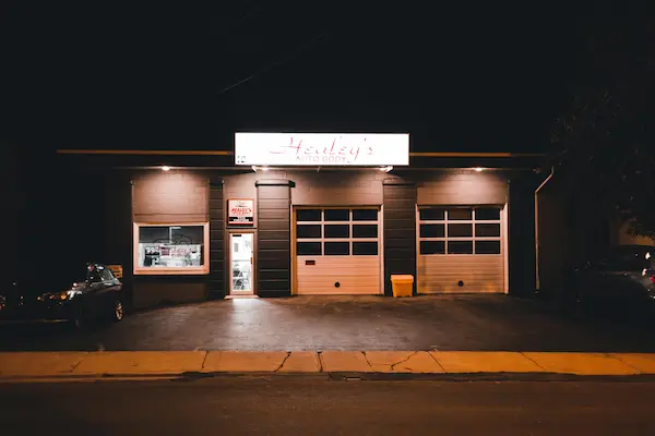 Black garage with white doors at night.