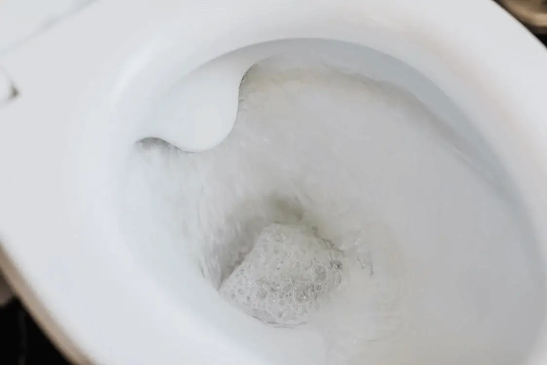 Toilet in the midst of flushing.