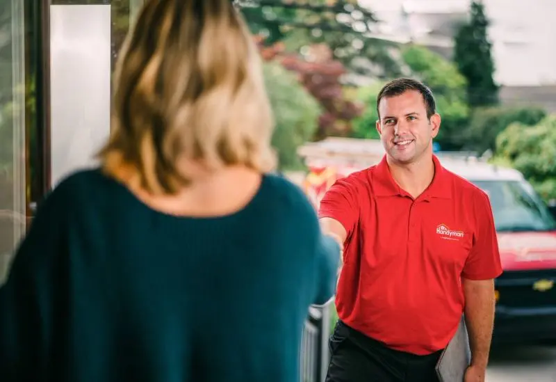 Mr. Handyman technician being greeted at door by customer.