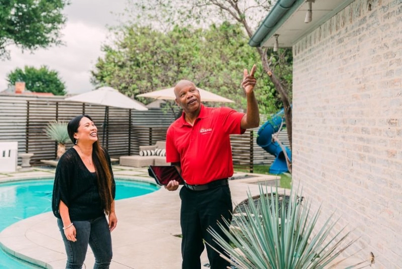 Handyman showing a Mr. Handyman customer the exterior of their home 