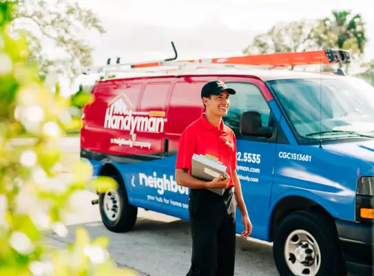 Mr. Handyman technician in a red uniform standing near a branded service van, ready to assist with professional handyman services in Brandon, FL.