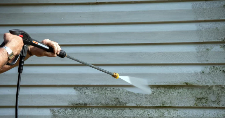 A handyman power washing in South Bend, IN.