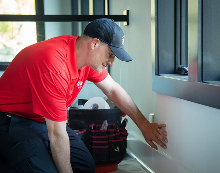 Mr. Handyman technician inspecting a wall during a drywall finishing appointment